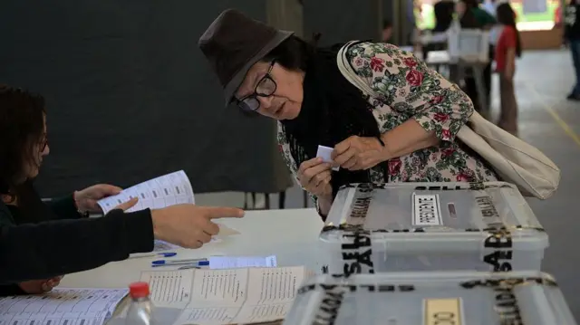 Una mujer depositando su voto en Chile